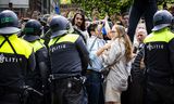 Leden van de Mobiele Eenheid (ME) verdrijven demonstranten voor de ingang van de Universiteit van Amsterdam (UvA) op de Roeterseilandcampus.