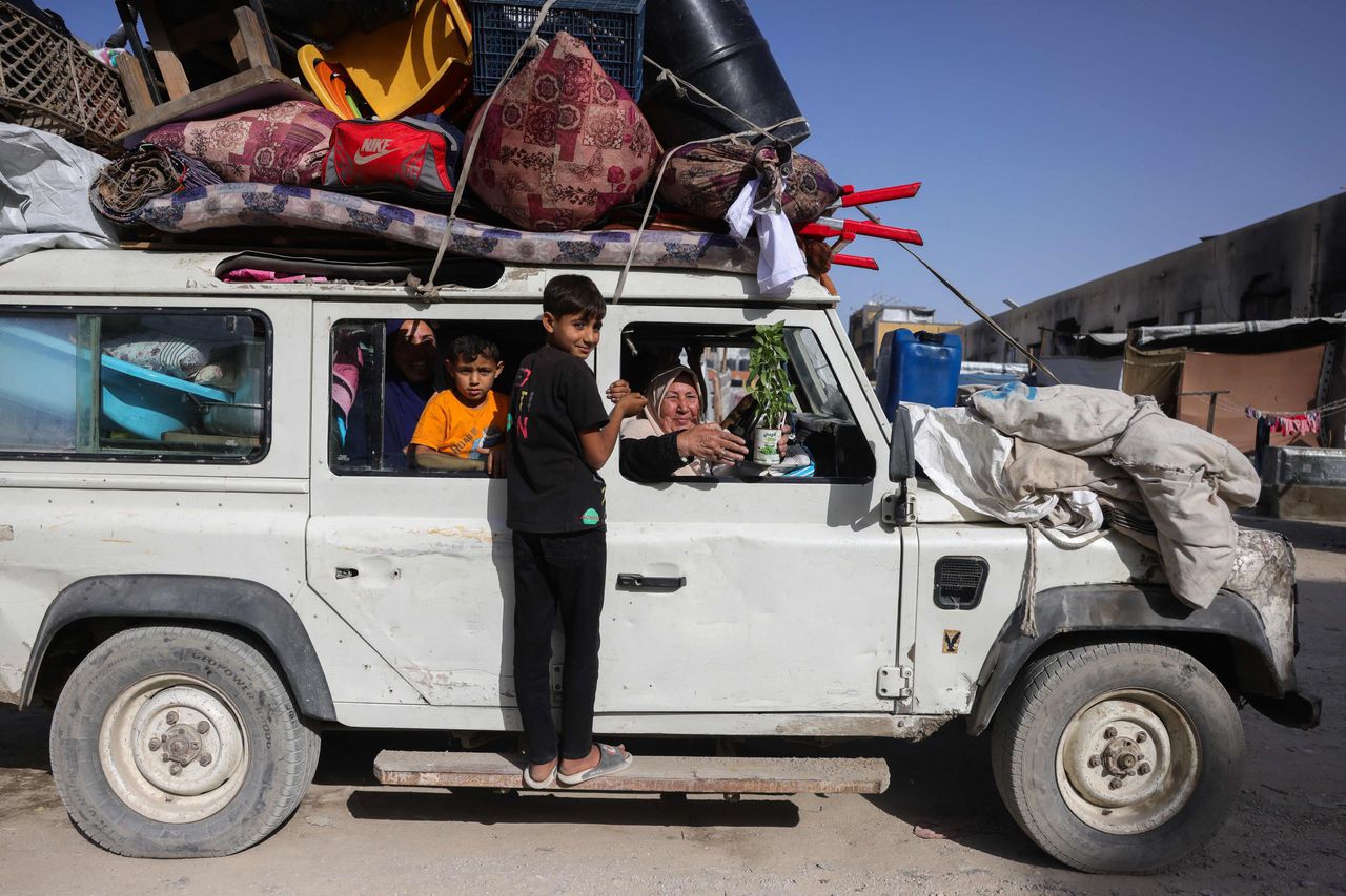 Een Palestijnse vrouw die Jabalia ontvlucht naar het zuiden laat haar basilicumplant aan de fotograaf Bashar Taleb zien.