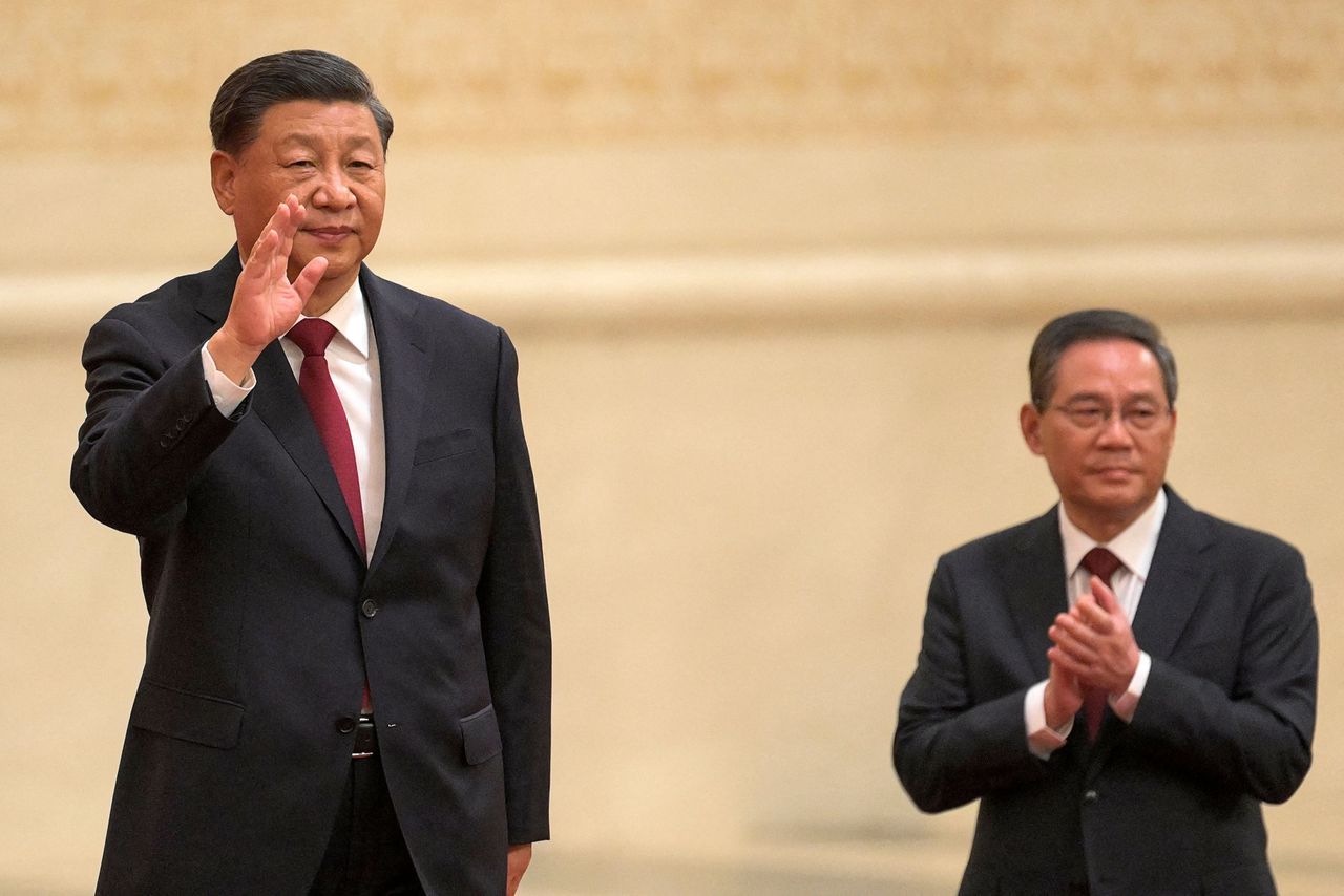 Li Qiang (rechts) aan de zijde van de wuivende partijleider, Xi Jinping, na het congres van de Communistische Partij van China, afgelopen weekeinde.