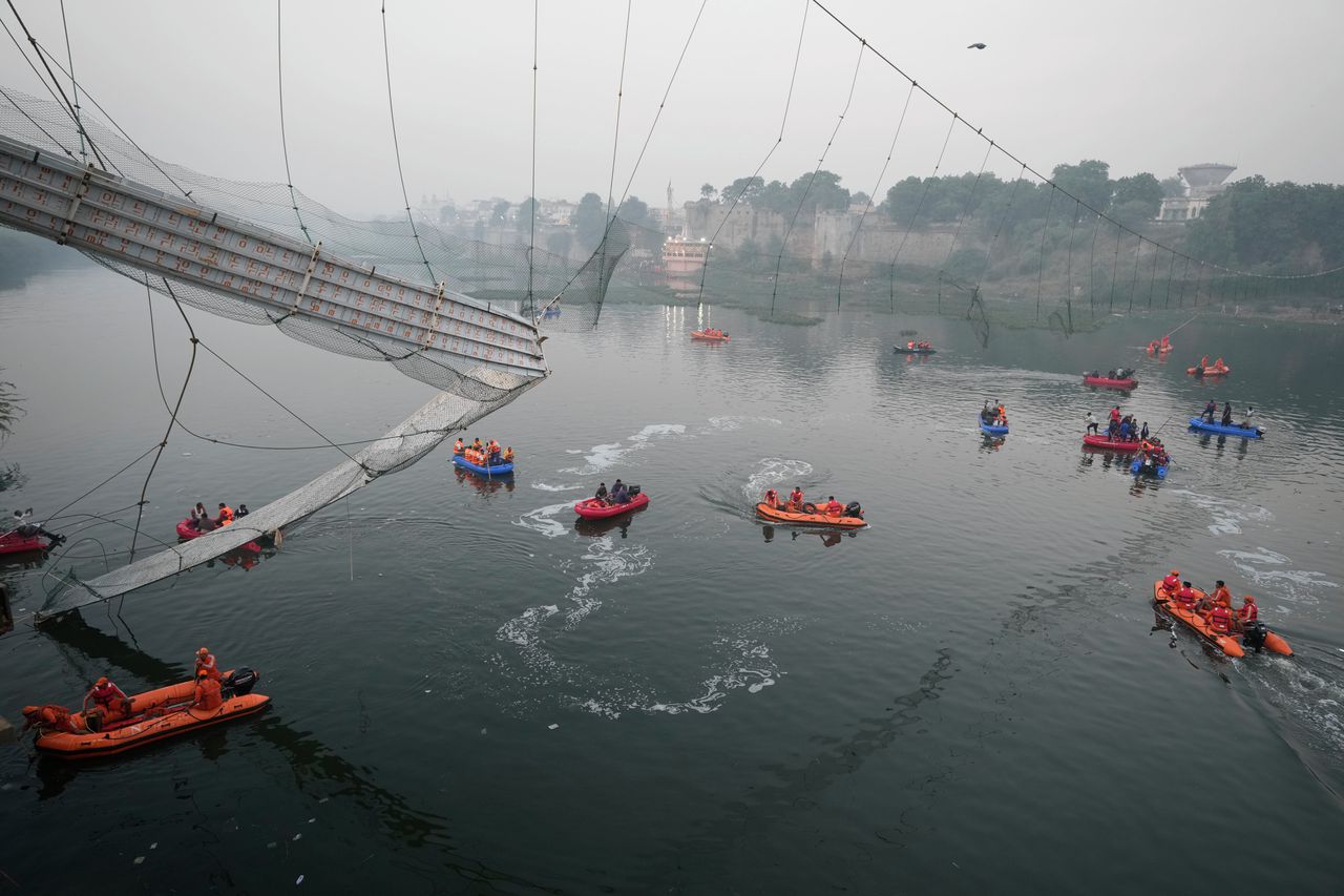 Reddingswerkers zoeken naar lichamen onder de ingestortte brug.