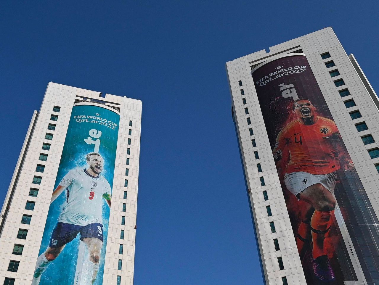 Banieren met foto's van teamcaptains Harry Kane (Engeland) en Virgil van Dijk (Nederland) in Doha.