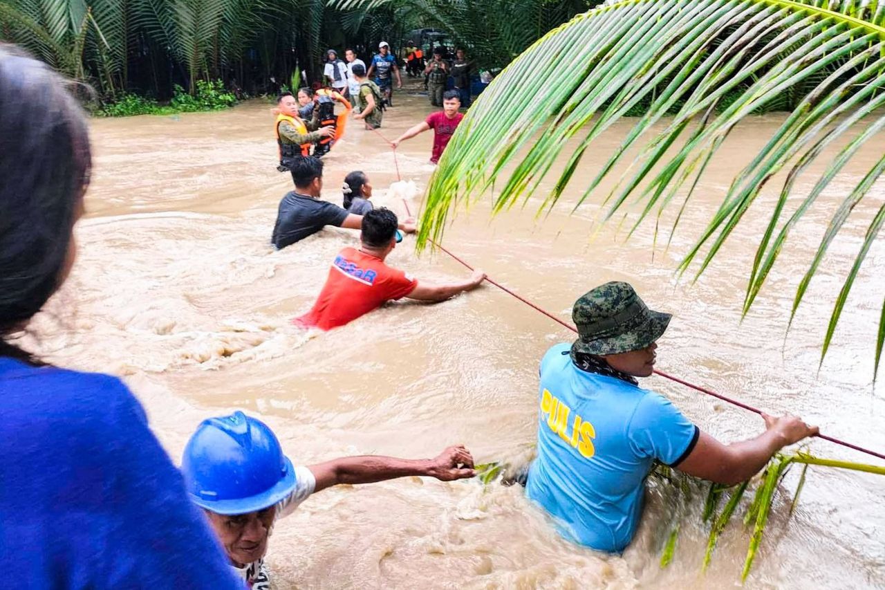 Reddingswerkers helpen mensen met evacueren in de gemeente Kalamansig.