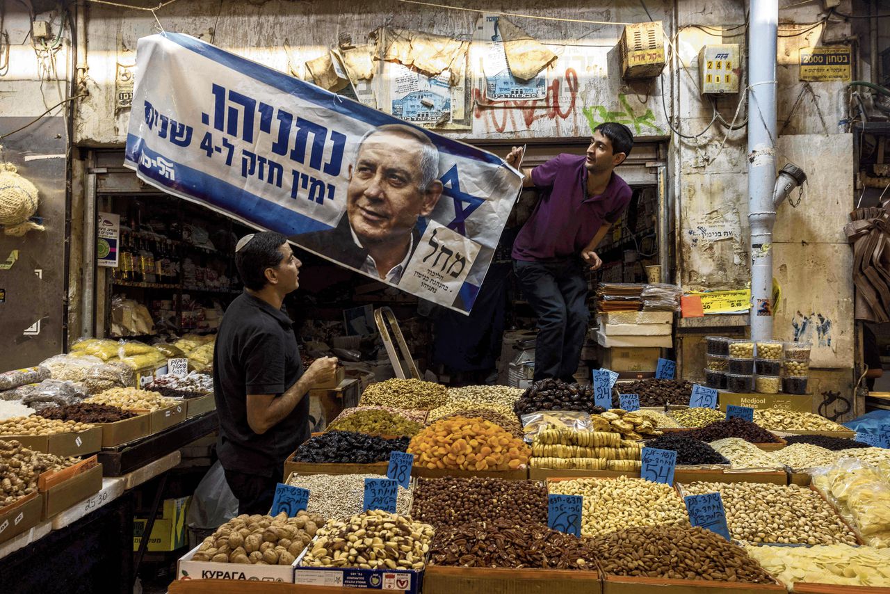 Verkiezingsspandoek van de Likud-partij van Netanyahu wordt één dag voor de verkiezingen gehesen in een winkel met noten en gedroogd fruit op een markt in Jeruzalem