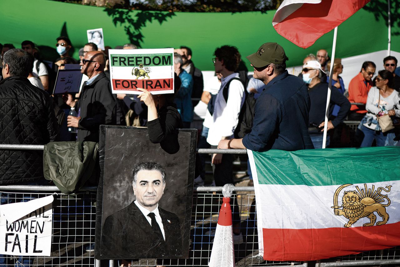 Demonstranten in Londen dragen een afbeelding van Reza Pahlavi, zoon van de sjah, mee.