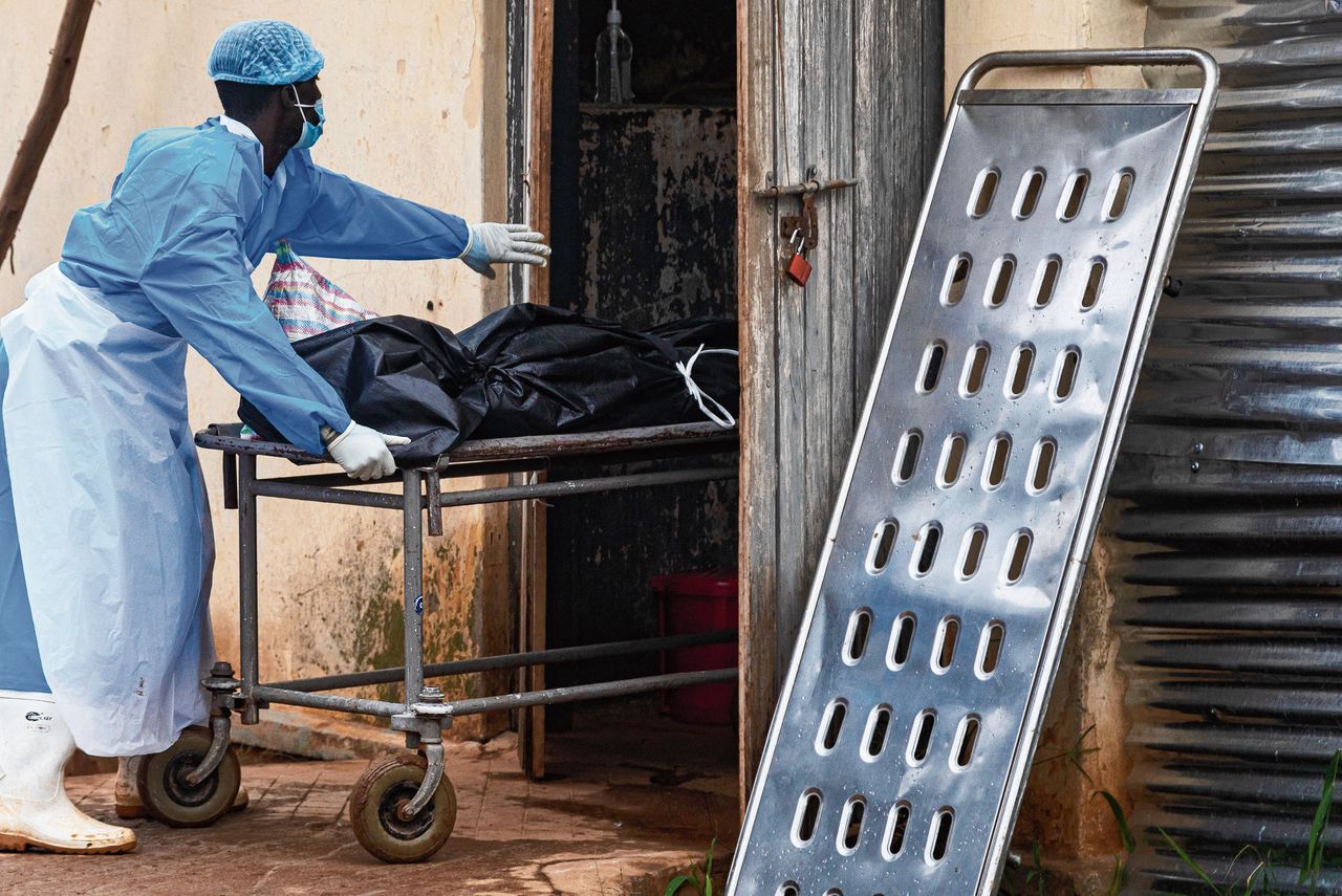 Een medewerker van het staatsziekenhuis in Mubende verplaatst een lichaam van een man van wie wordt vermoed dat hij stierf aan ebola.