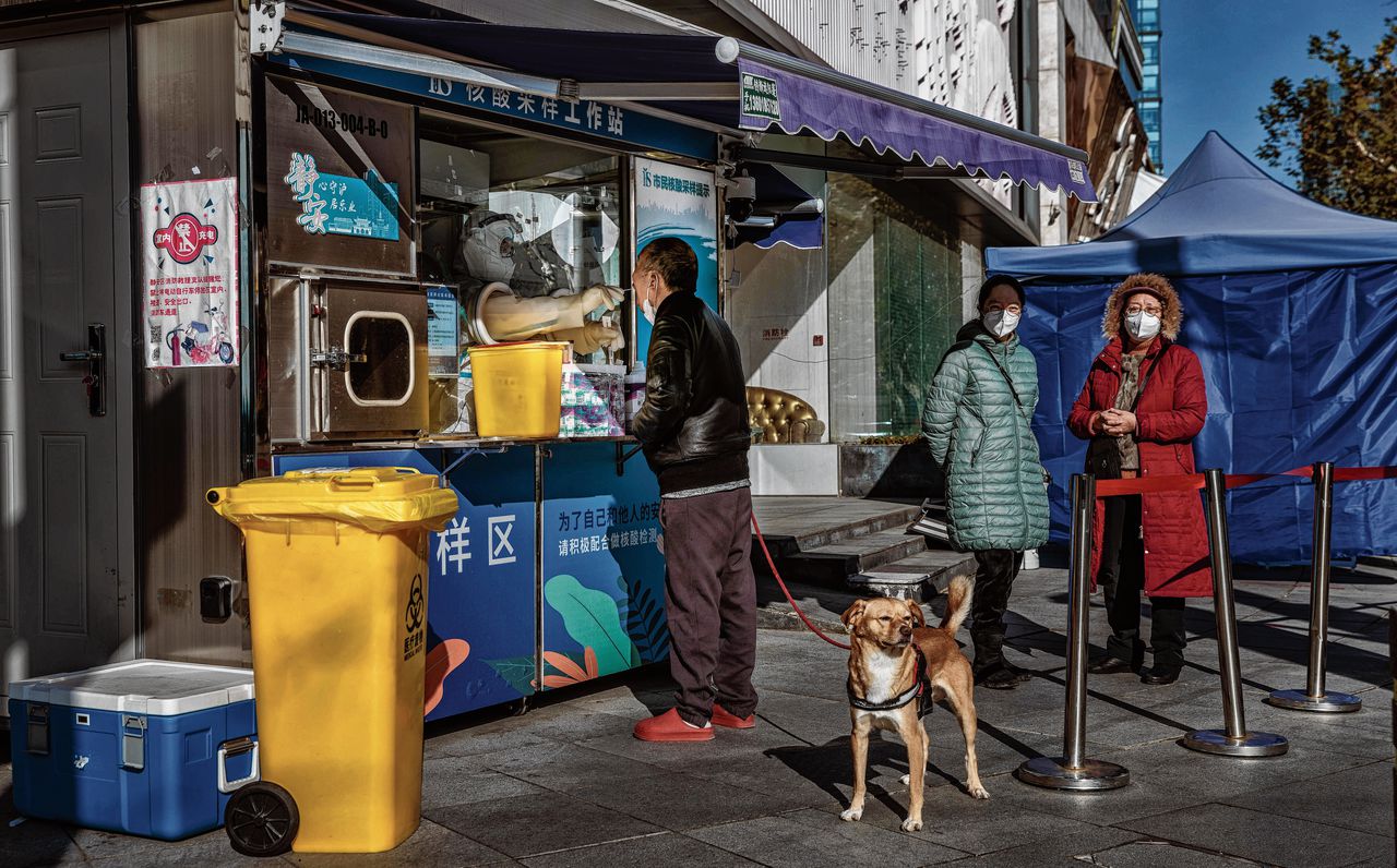 Inwoners van Shanghai doen een PCR-test op straat. Intussen zijn in de staat 2.594 ‘koortsklinieken’ geopend vanwege de toenemende vraag naar behandeling en medicatie.