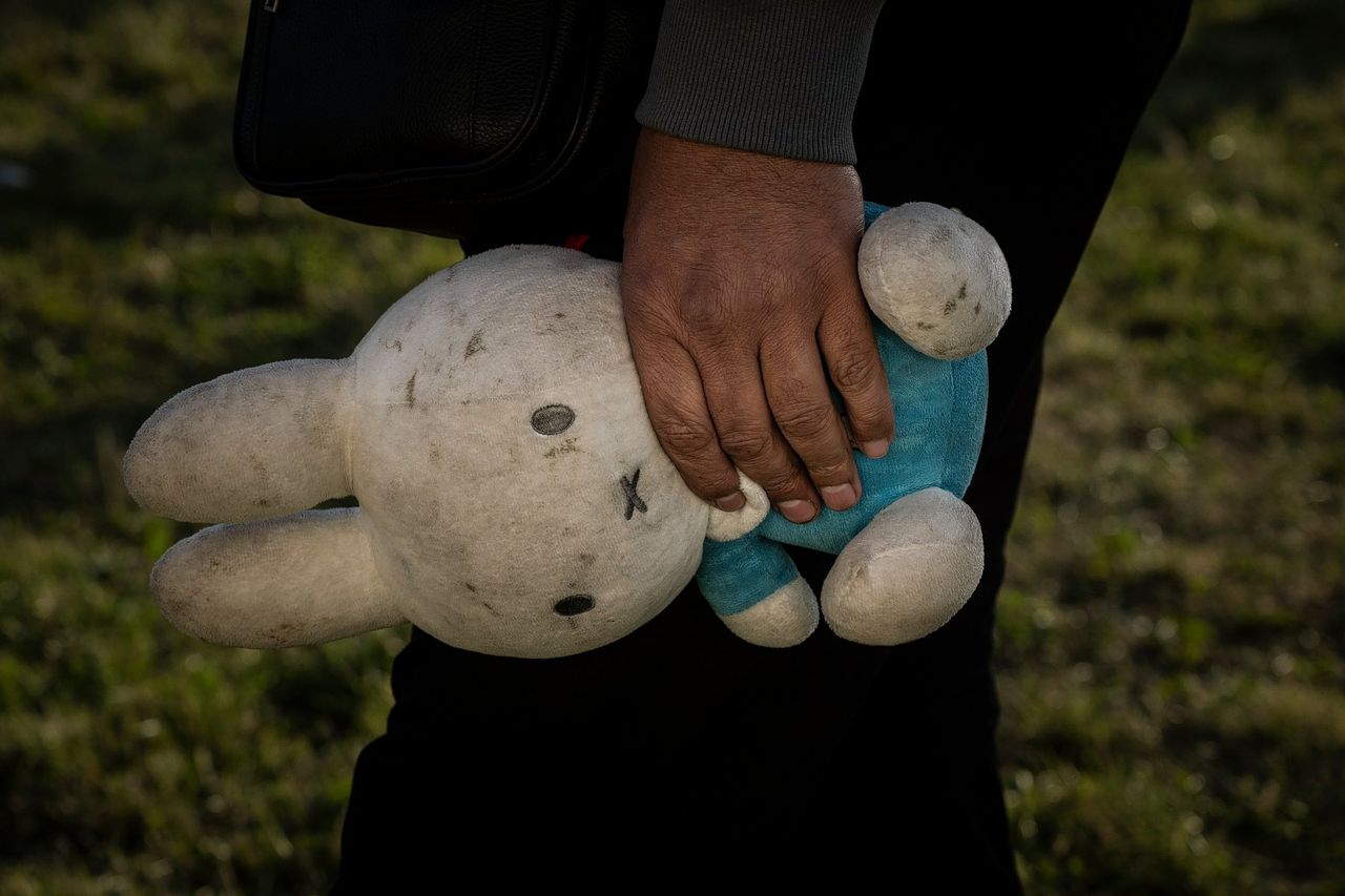 Een kind houdt een knuffel vast in opvangcentrum Ter Apel in juli van dit jaar. In het asielcomplex is het regelmatig zo druk geweest dat asielzoekers buiten moesten slapen.