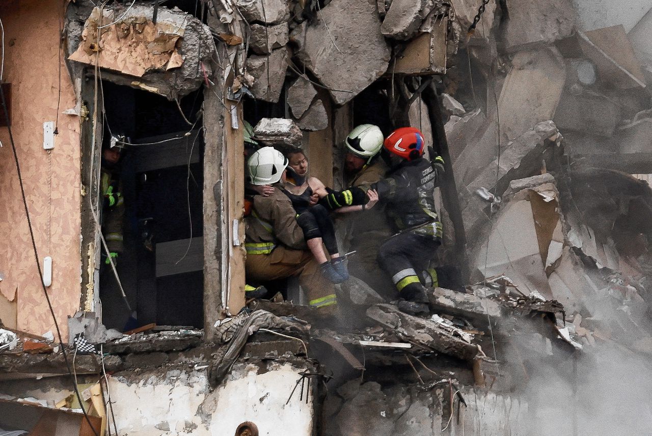 Reddingswerkers dragen een vrouw weg uit een flat in Dnipro die zwaar is beschadigd bij een Russische raketaanval zaterdag. In heel Oekraïne werden burgerdoelen getroffen door Russische raketten.