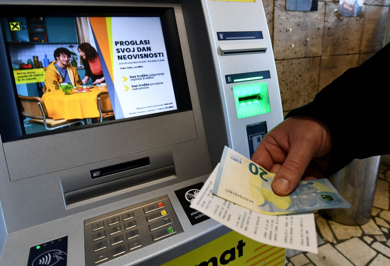 Een klant haalt op 1 januari 2023 eurobankbiljetten uit een pinautomaat in Zagreb, de hoofdstad van Kroatië. De euro is de nieuwe Kroatische munteenheid.