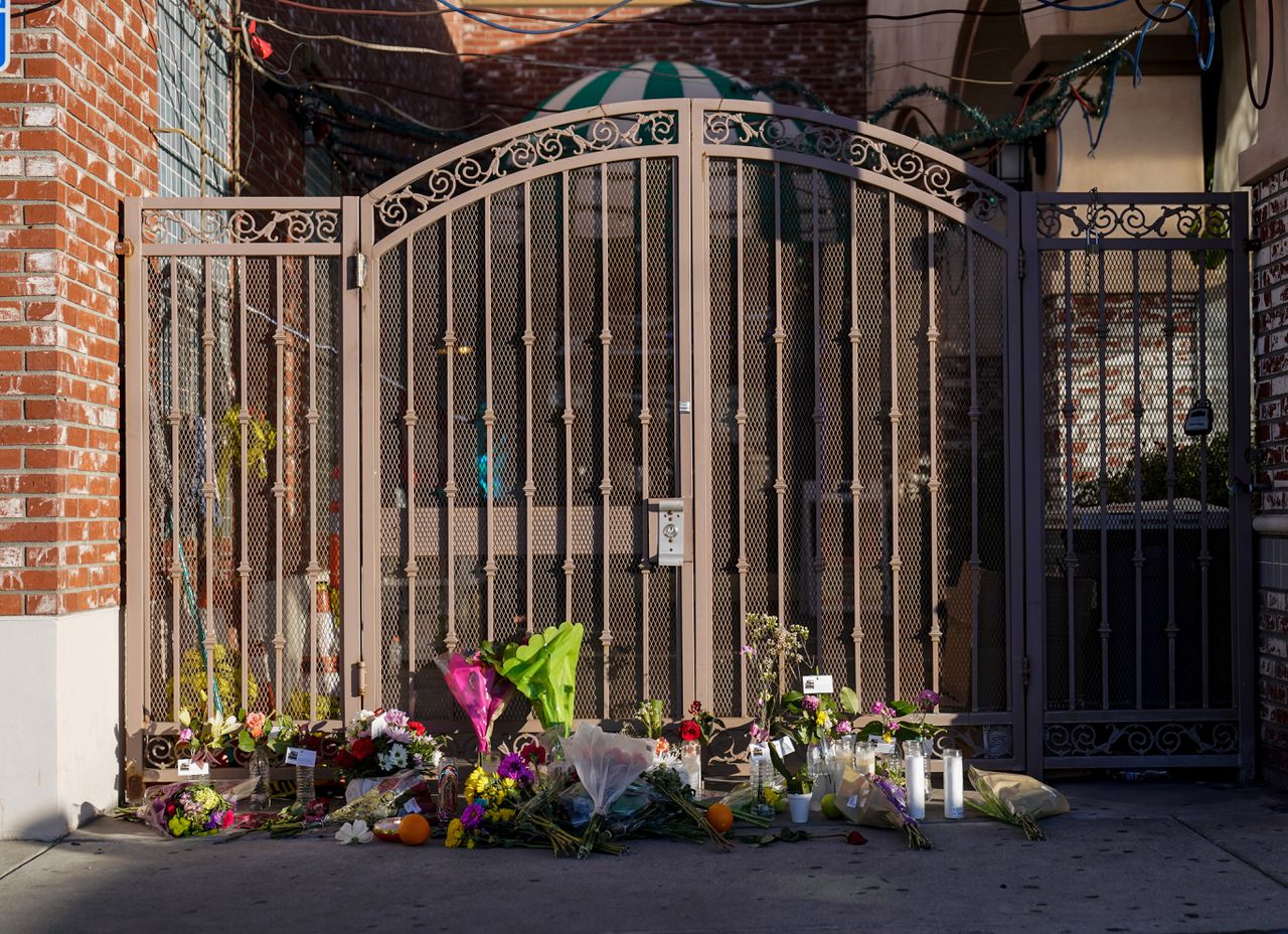 Bloemen zijn neergelegd voor het hek van de dansstudio waar een schutter zaterdag het vuur opende en zo elf mensen doodde.