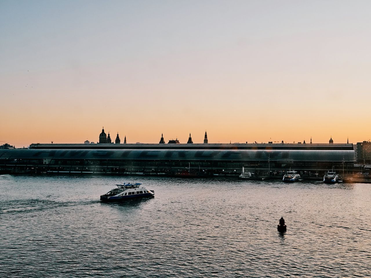 Deel van het IJ bezien vanaf de noordoever, met zicht op Amsterdam Centraal.