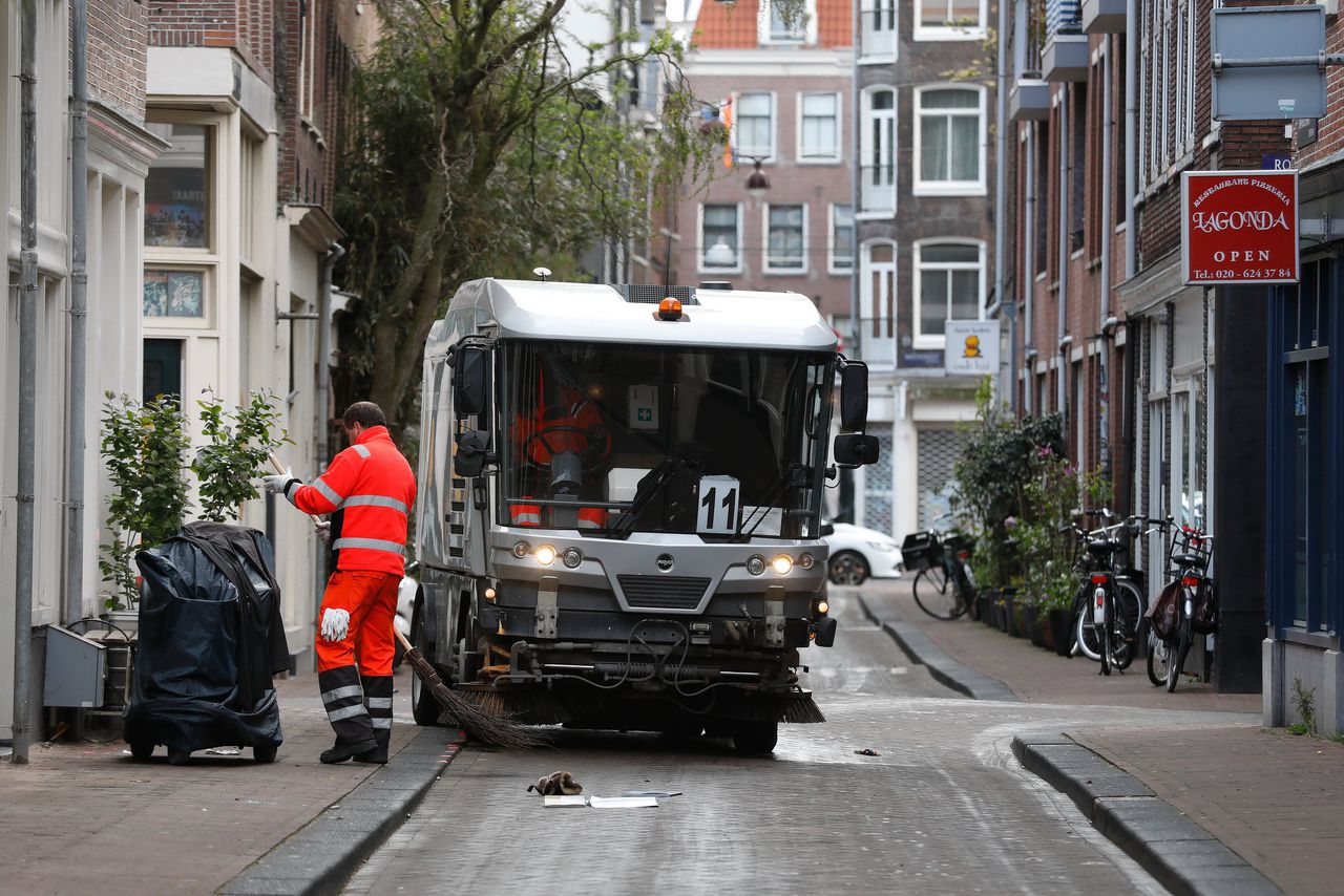 Straatvegers na de viering van Koningsdag in Amsterdam.