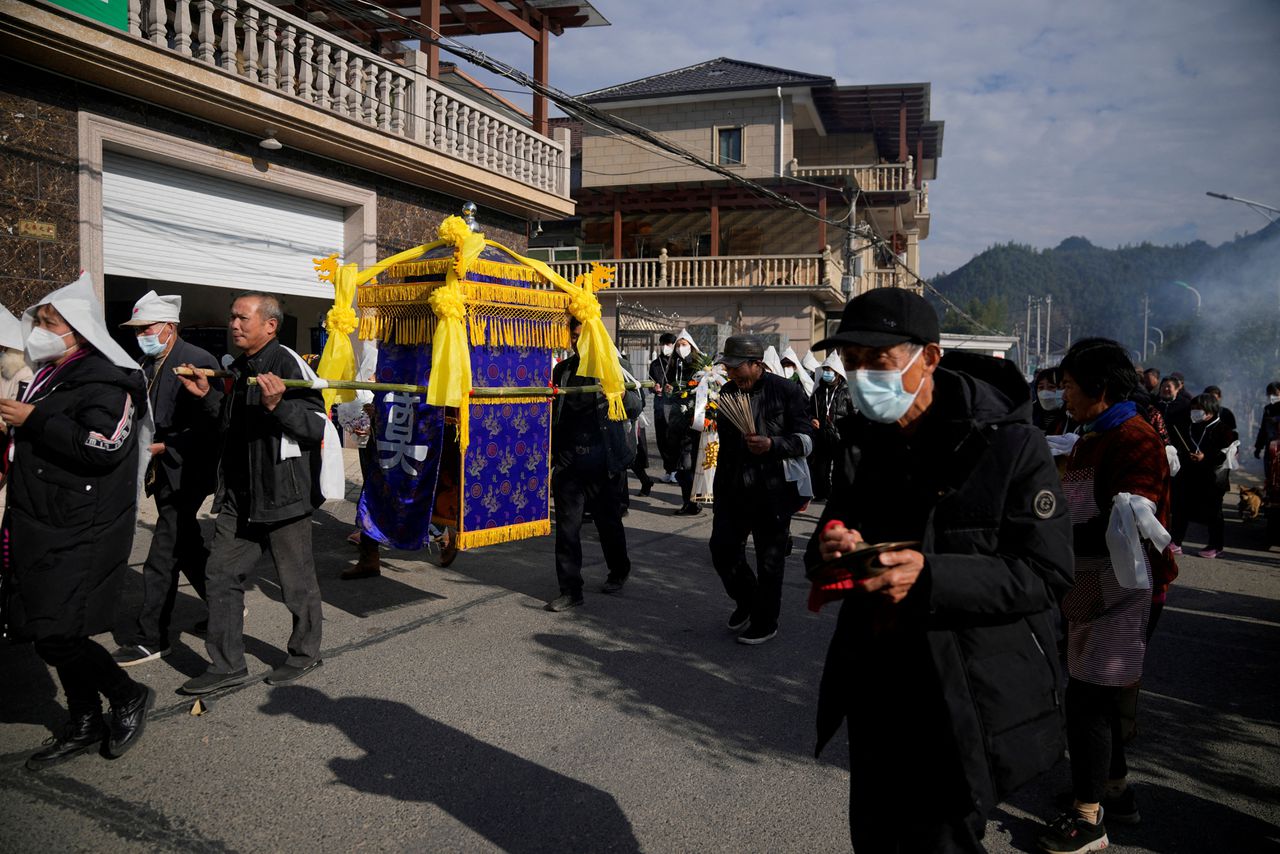 Nabestaanden bezoeken in de Chinese plaats Tonglu County de begrafenis van iemand die overleed aan het coronavirus.