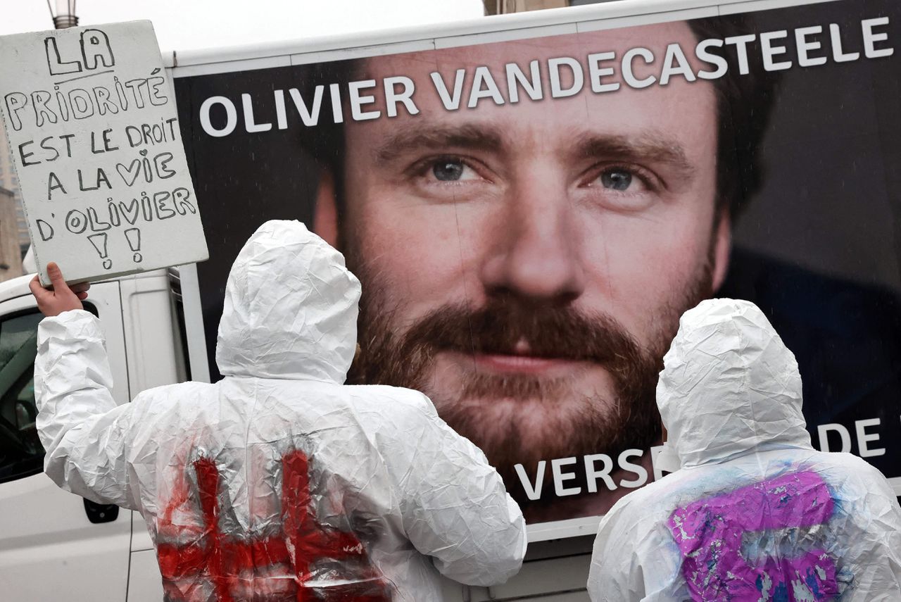 Demonstranten houden borden omhoog tijdens een protest in Brussel, vanwege de arrestatie van Olivier Vandecasteele Foto François Walschaerts / AFP