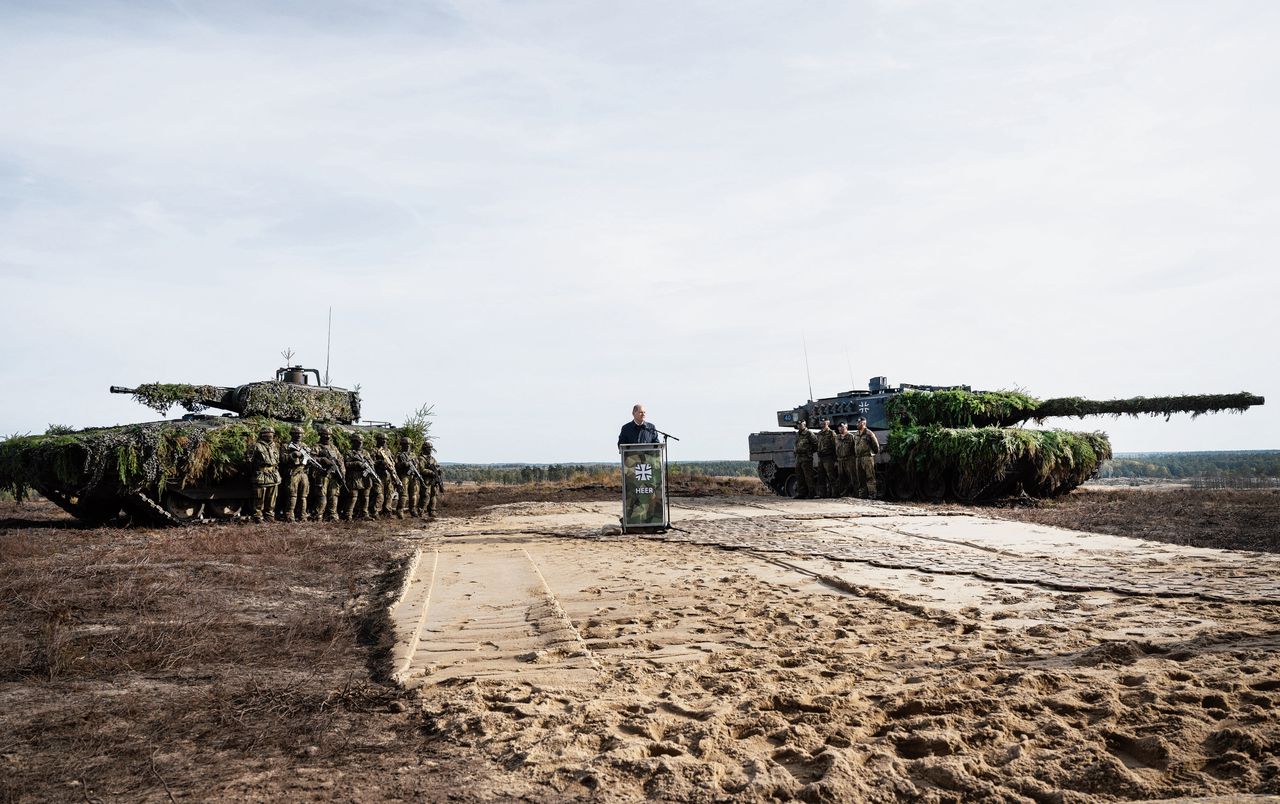 De Duitse Bondskanselier Olaf Scholz oktober bij een trainingscentrum van de Bundeswehr in Ostenholz, tussen een Puma-gevechtsvoertuig (links) en een Leopard 2-tank.