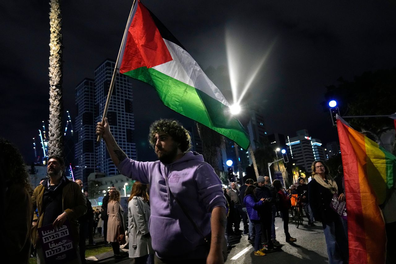 Een betoger met de Palestijnse vlag tijdens een demonstratie tegen de nieuwe Israëlische regering in Tel Aviv zondag. Foto Tsafrir Abayov/AP