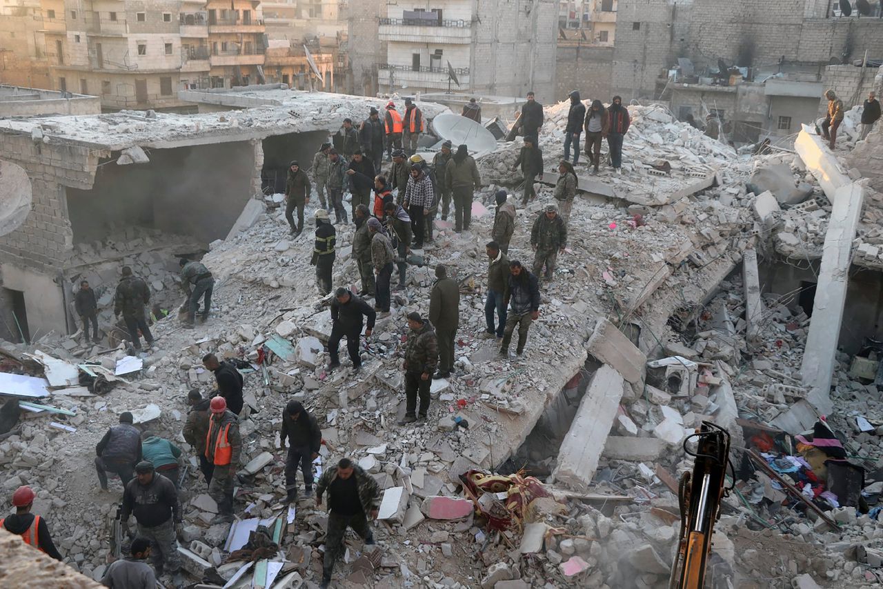 Mensen zoeken naar overlevenden in het puin van het ingestorte woongebouw in Aleppo, Syrië.