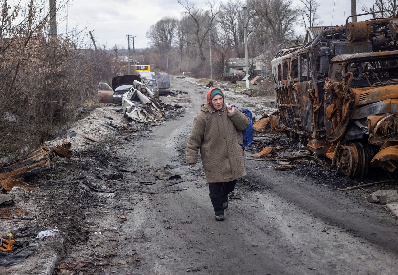 Een vrouw loopt langs de ravage die Russische beschietingen aanrichtten in het dorpje Torkse, in de regio Donetsk.