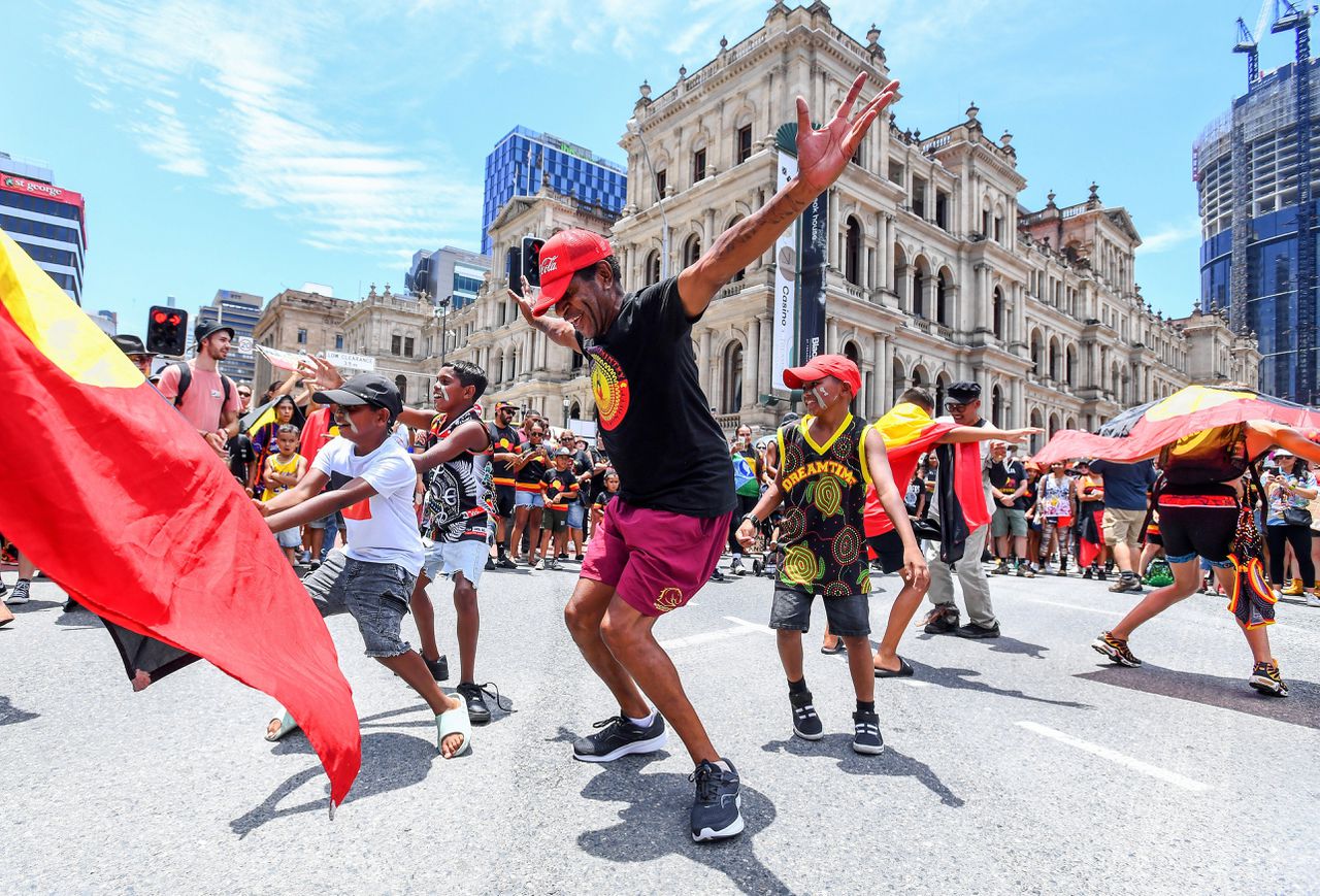 Deelnemers aan een protestmars ter gelegenheid van wat zij ‘Invasion Day' noemen dansen op straat in Brisbane op donderdag, de nationale feestdag van Australië.