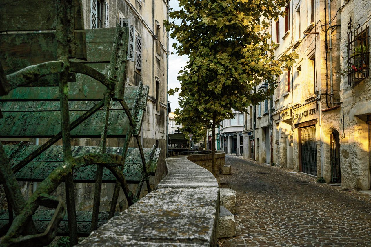 Een straat in het Franse Avignon met vier watermolens in een rechthoekige goot.