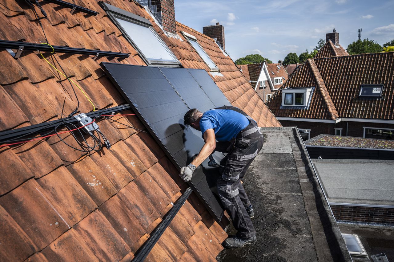 Op dak van een huis in het Groningse Haren worden zonnepanelen geplaatst. De subsidie voor zonnestroom staat al jaren ter discussie.