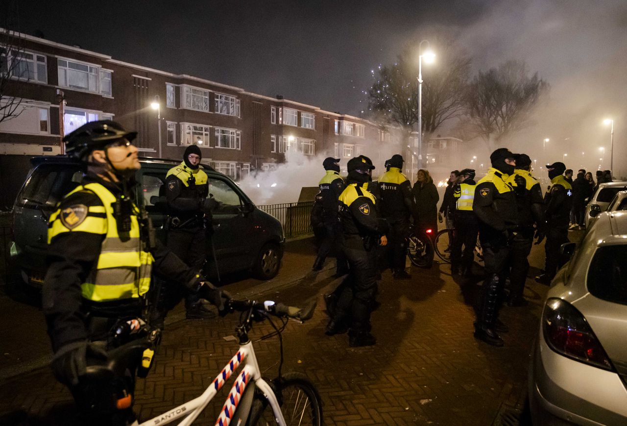 ME'ers in Den Haag beschermen tijdens de nieuwjaarsnacht brandweerlieden.