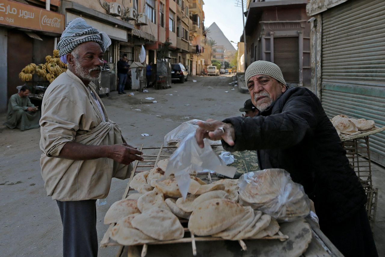 Een man verkoopt brood op straat in Nazlet El-Semman.