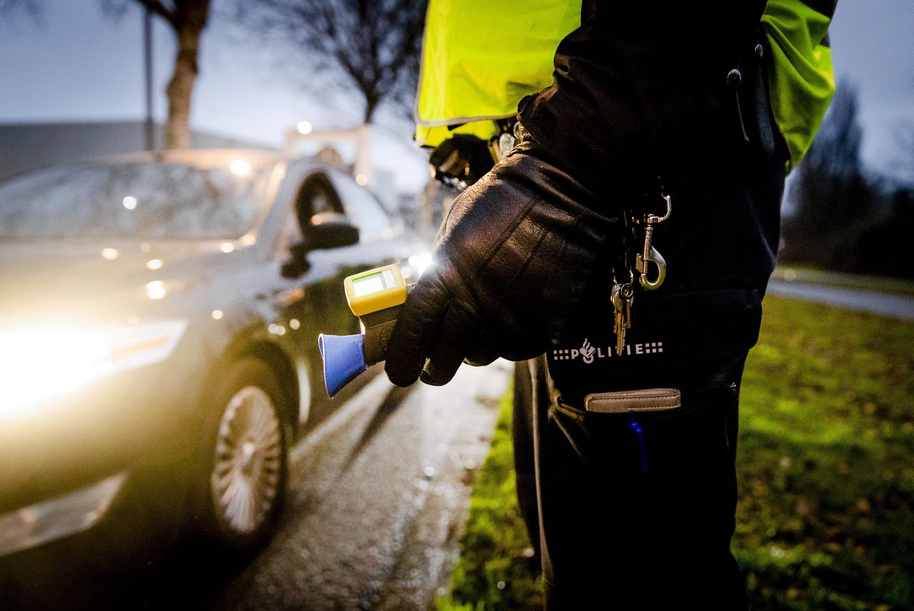 Een politieagent voert een alcoholcontrole uit tijdens een verkeerscontrole in Rotterdam