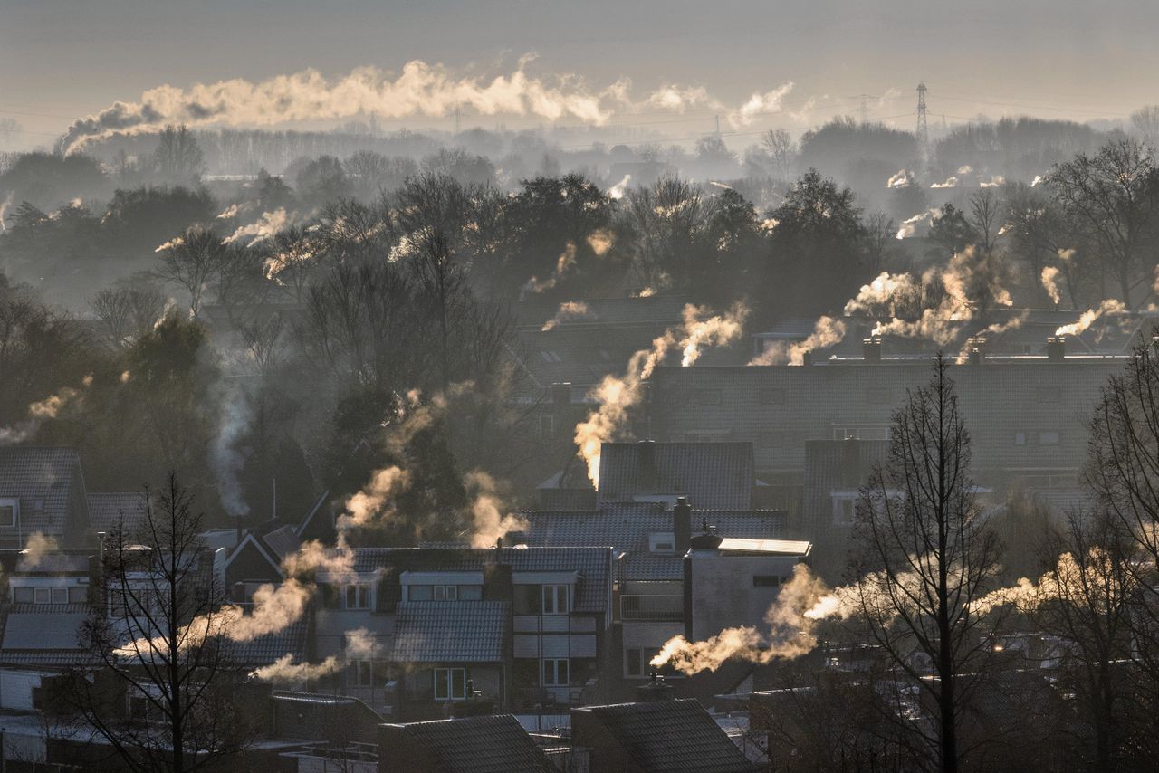 Rokende schoorstenen tijdens een koude ochtend boven een woonwijk in Heerhugowaard tijdens een koude ochtend in de eerste winterdagen van het jaar. Door de verder zachte winter zijn de gasprijzen op de energiemarkt flink gedaald.