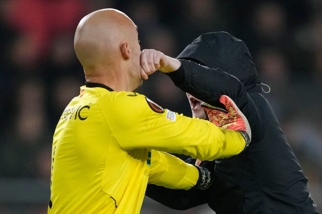 De doelman van Sevilla Marko Dmitrovic probeert tijdens de wedstrijd tegen PSV op het veld een man van zich af te houden.