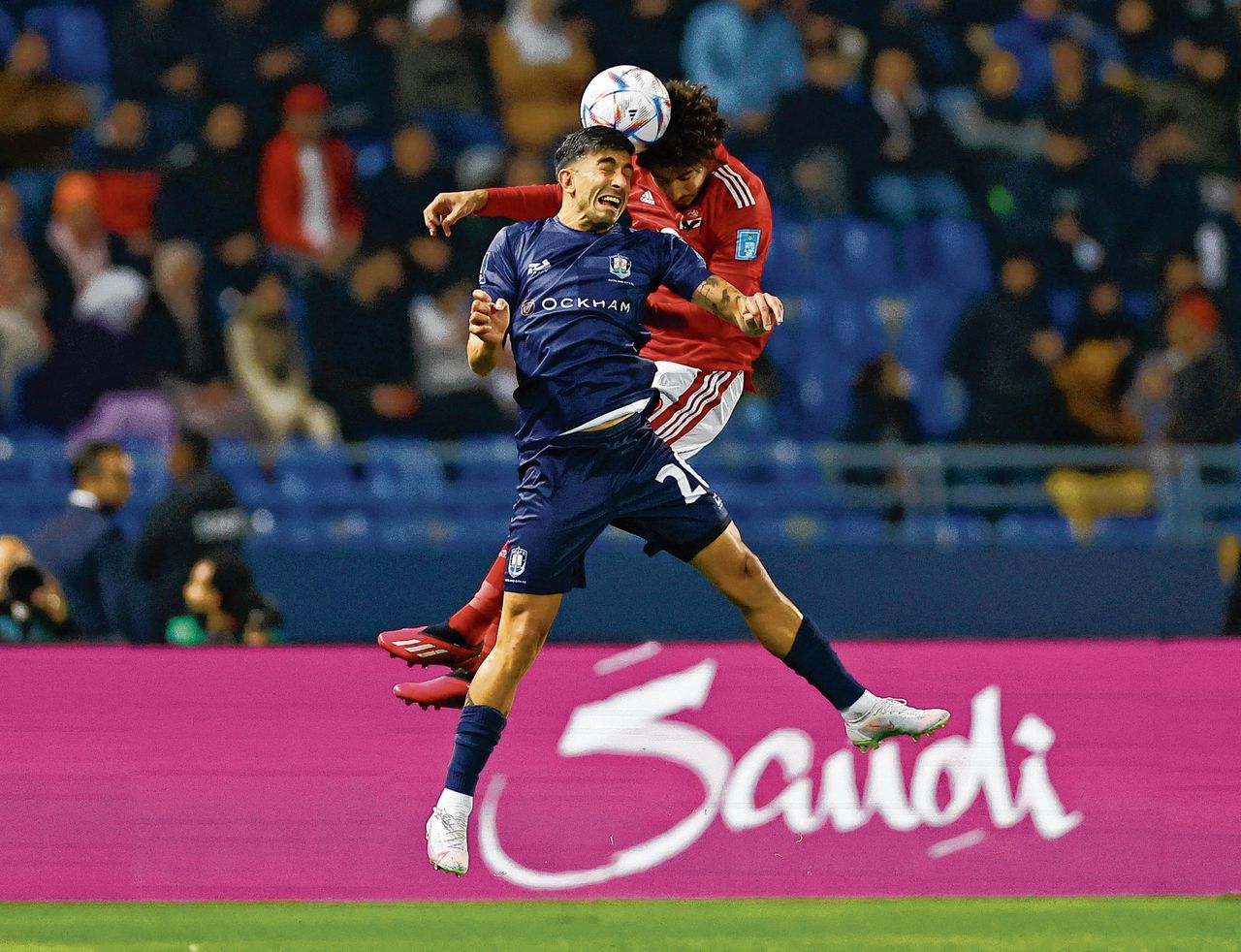 Een kopduel in de play-offwedstrijd van het WK voor clubs tussen Al Ahly (rood shirt) en Auckland City (3-0).