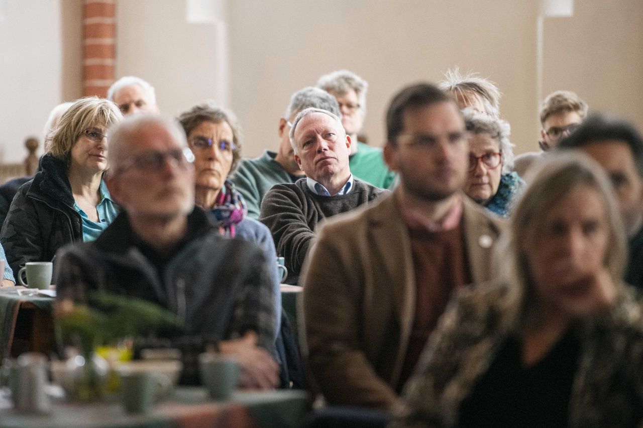 Bewoners van het aardbevingsgebied kijken in de Petrus en Pauluskerk in Loppersum naar de presentatie van het eindrapport van de parlementaire enquêtecommissie.