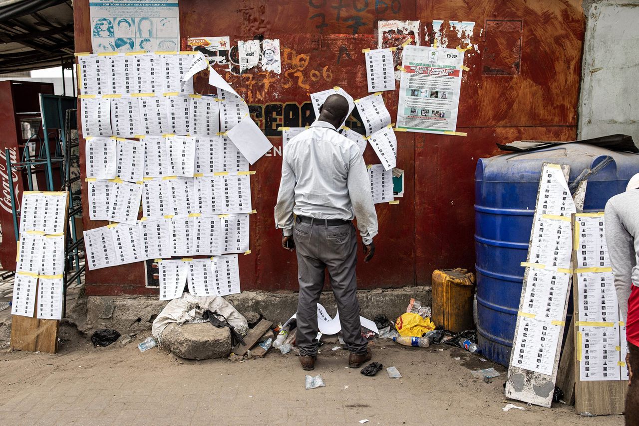 Een kiezer in Lagos zoekt zijn naam op een lijst met stemgerechtigden. Zaterdag ging het land met de grootste bevolking van Afrika naar de stembus om onder meer een nieuwe president te kiezen.