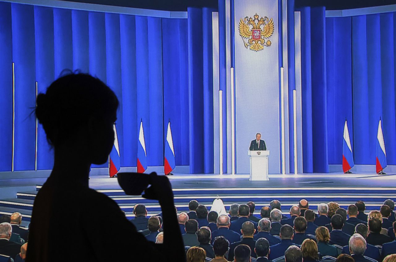 Een vrouw kijkt naar de toespraak van de Russische president Vladimir Poetin in haar huis in Moskou. Het evenement wordt live uitgezonden op Russische televisie.