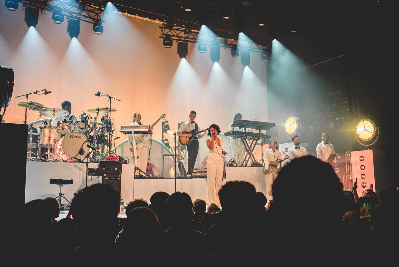 Raye geflankeerd door haar zevenkoppige band, inclusief saxofoon, trompet en trombone in Melkweg.