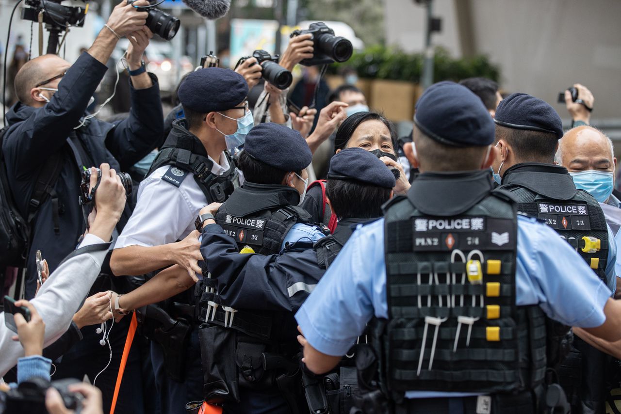 Chan po-ying werd maandag omringd door politieagenten bij het begin van het proces tegen 47 prodemocratische activisiten in Hongkong. Haar echtgenoot Leung Kwok-heung is een van de beklaagden.