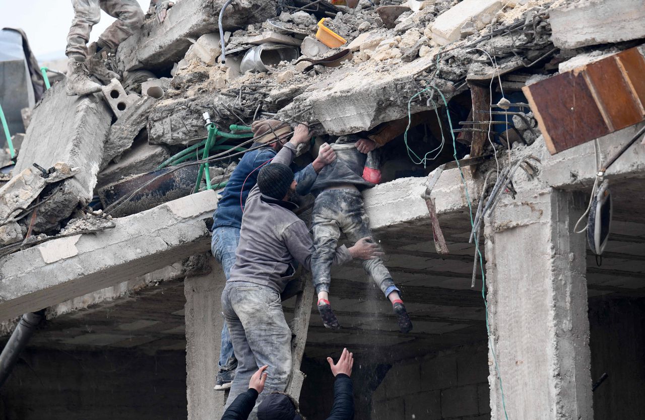 Bewoners van het stadje Jandaris, in door opstandelingen beheerst gebied in het noordwesten van Syrië, bevrijden een gewond meisje uit het puin van een ingestort gebouw.