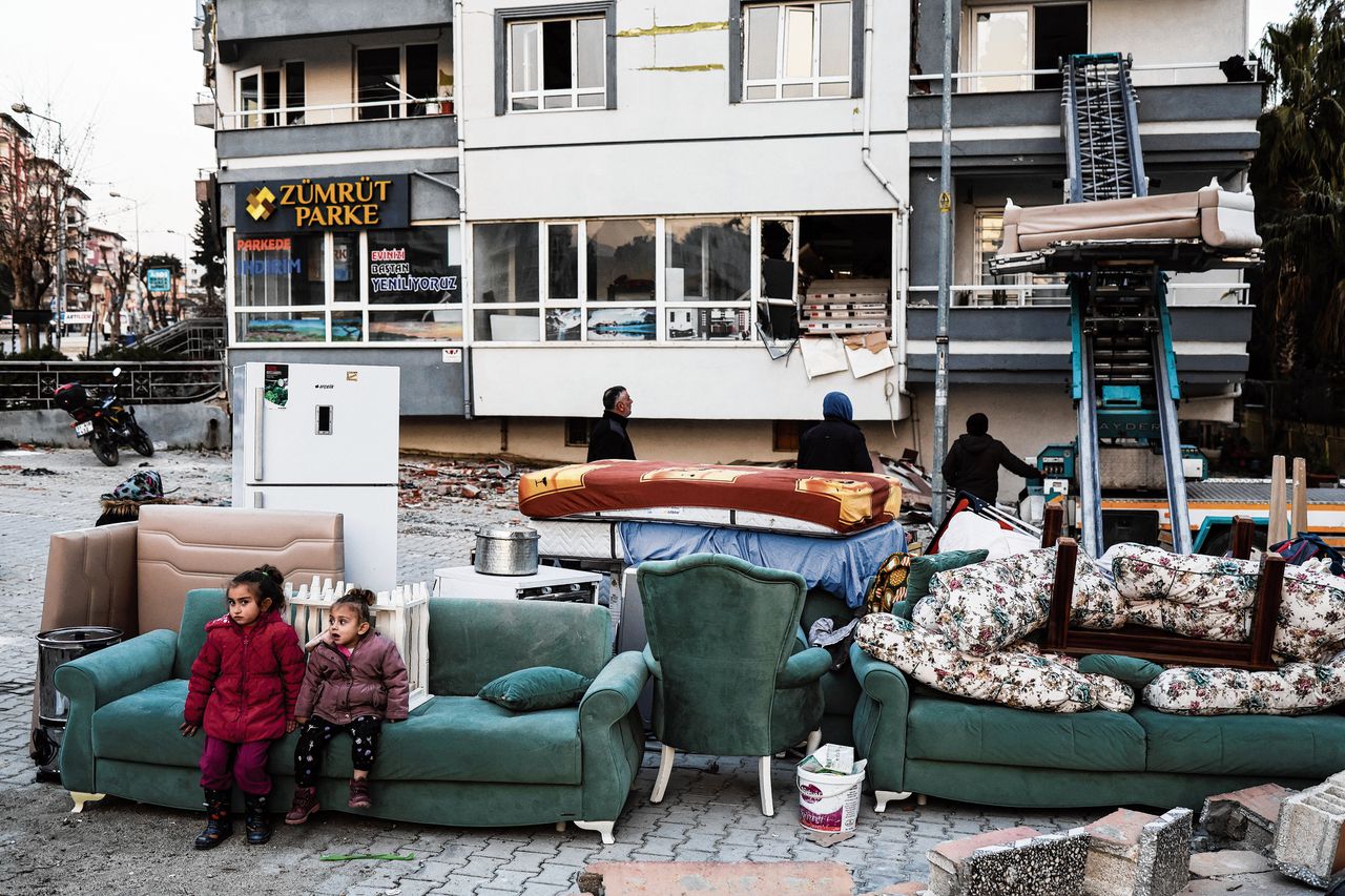 Een familie haalt donderdag met hulp van een verhuisbedrijf haar bezittingen uit een beschadigde woning in de Turkse stad Antakya.