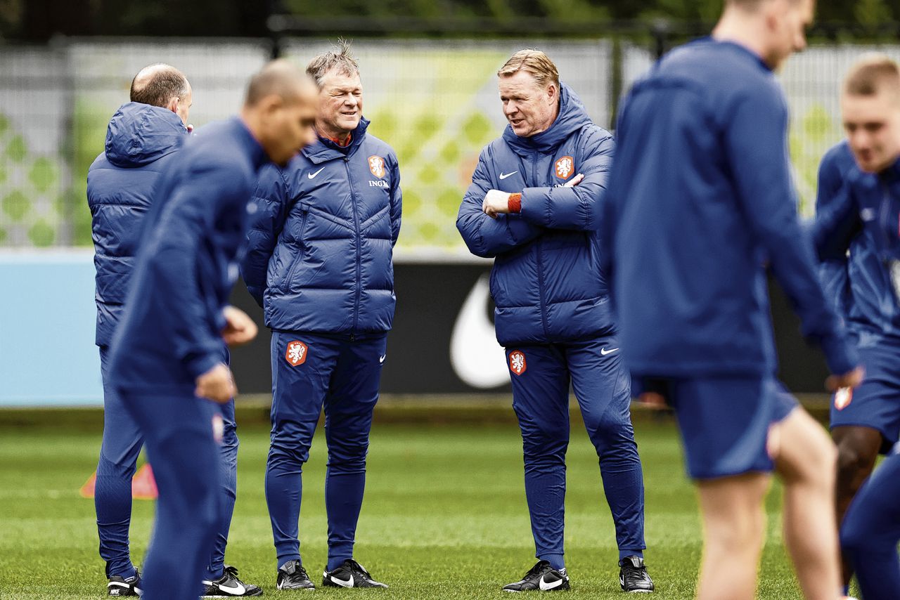 Bondscoach Ronald Koeman (midden, rechts) overlegt met zijn broer en assistent Erwin bij een training van Oranje.