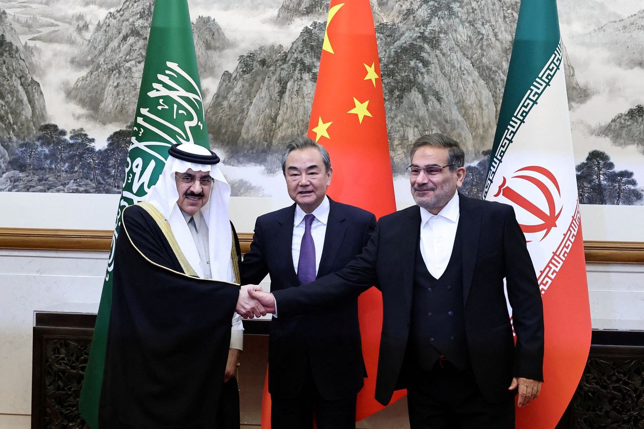 De Saoedische en Iraanse onderhandelaars Musaed bin Mohammed Al-Aiban (links) en Ali Shamkhani (rechts) vrijdag in Beijing met de Chinese minister van Buitenlandse Zaken Wang Yi.