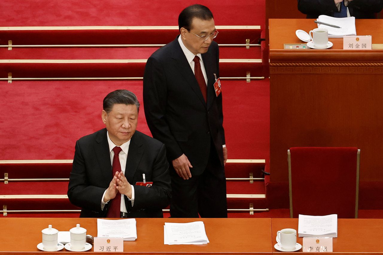 De Chinese premier Li Keqiang keert terug naar zijn stoel naast president Xi Jinping na een toespraak bij de opening van het Nationale Volkscongres in Beijing op zondag.