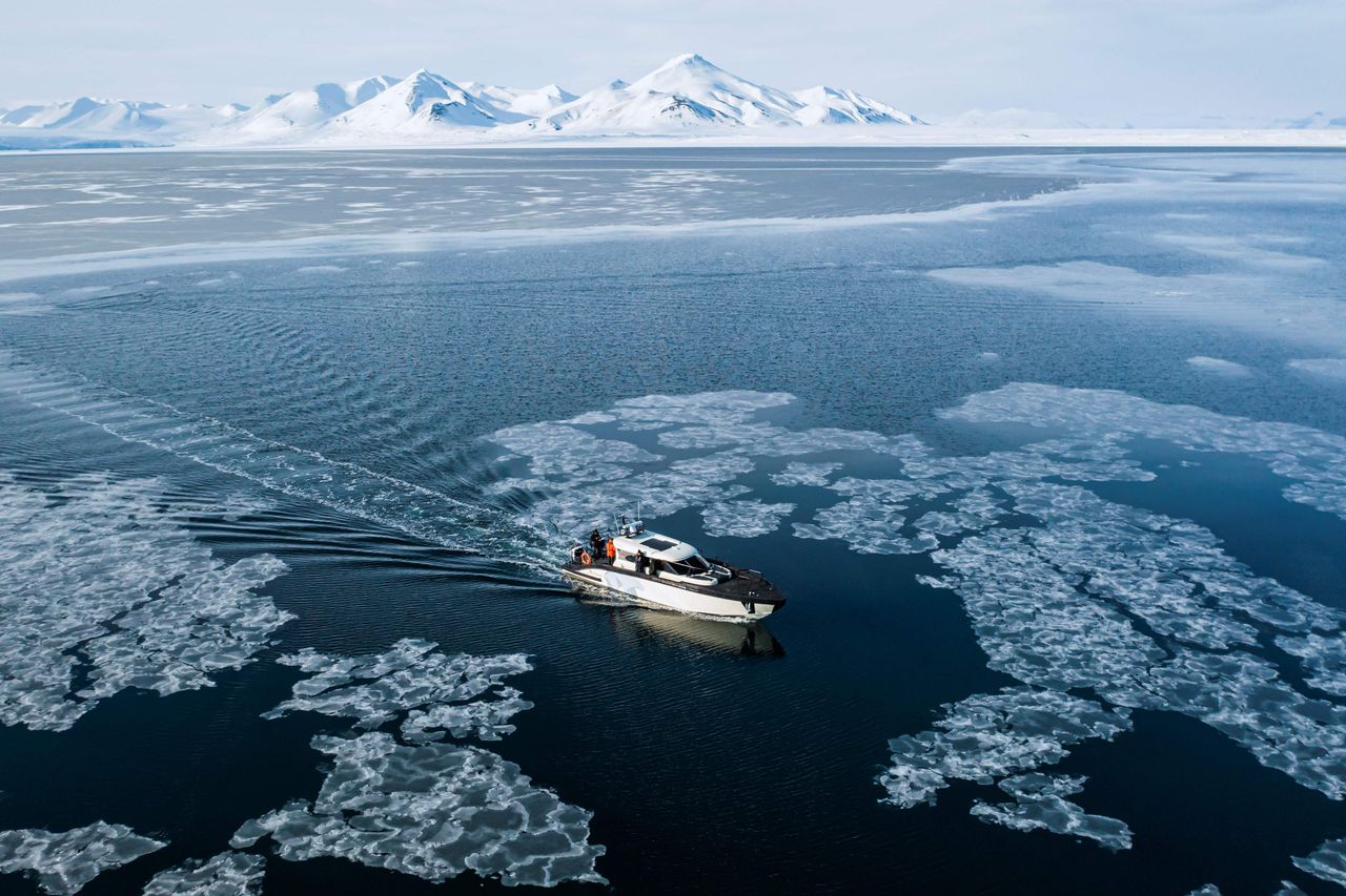 Een hybride boot vaart door de ijsschotsen in Borebukta, een baai aan de westelijke kant van de Noorse eilandengroep Spitsbergen.