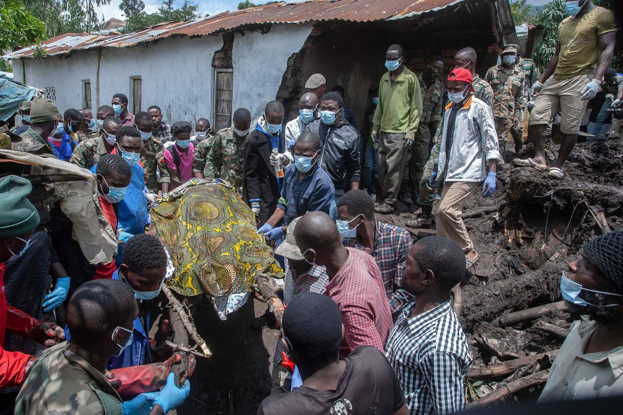Malawische militairen halen het lichaam van een slachtoffer van tropische storm Freddy onder de modder en het puin vandaan.
