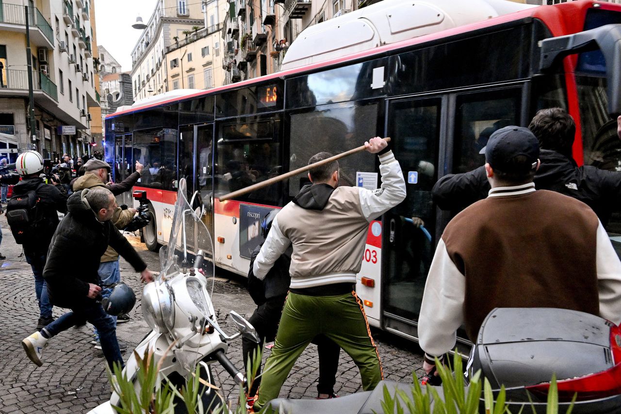 Voetbalhooligans vernielen een bus in Napels.