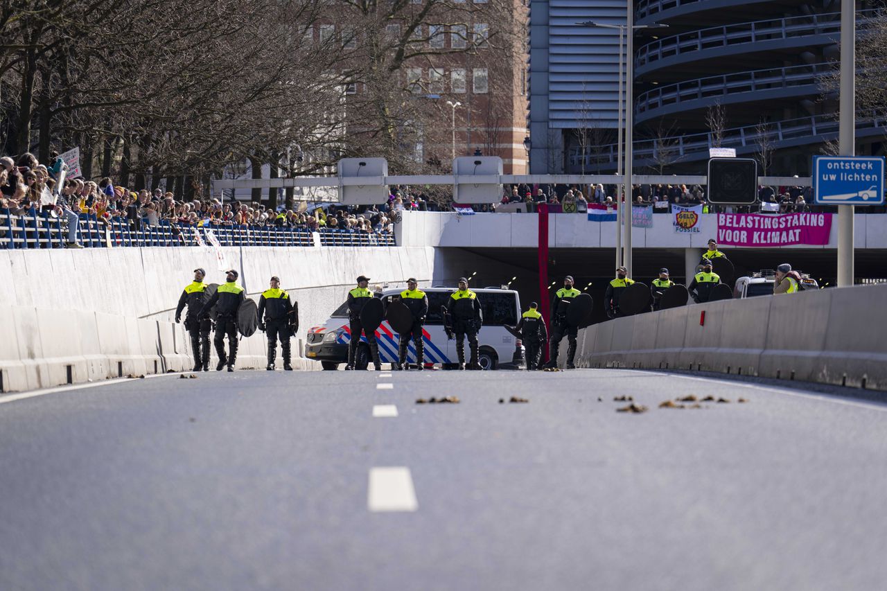 Vanuit verschillende kanten van de weg gingen een paar duizend klimaatactivisten de Utrechtsebaan op en namen zittend plaats bij de ingang van de tunnelbak.