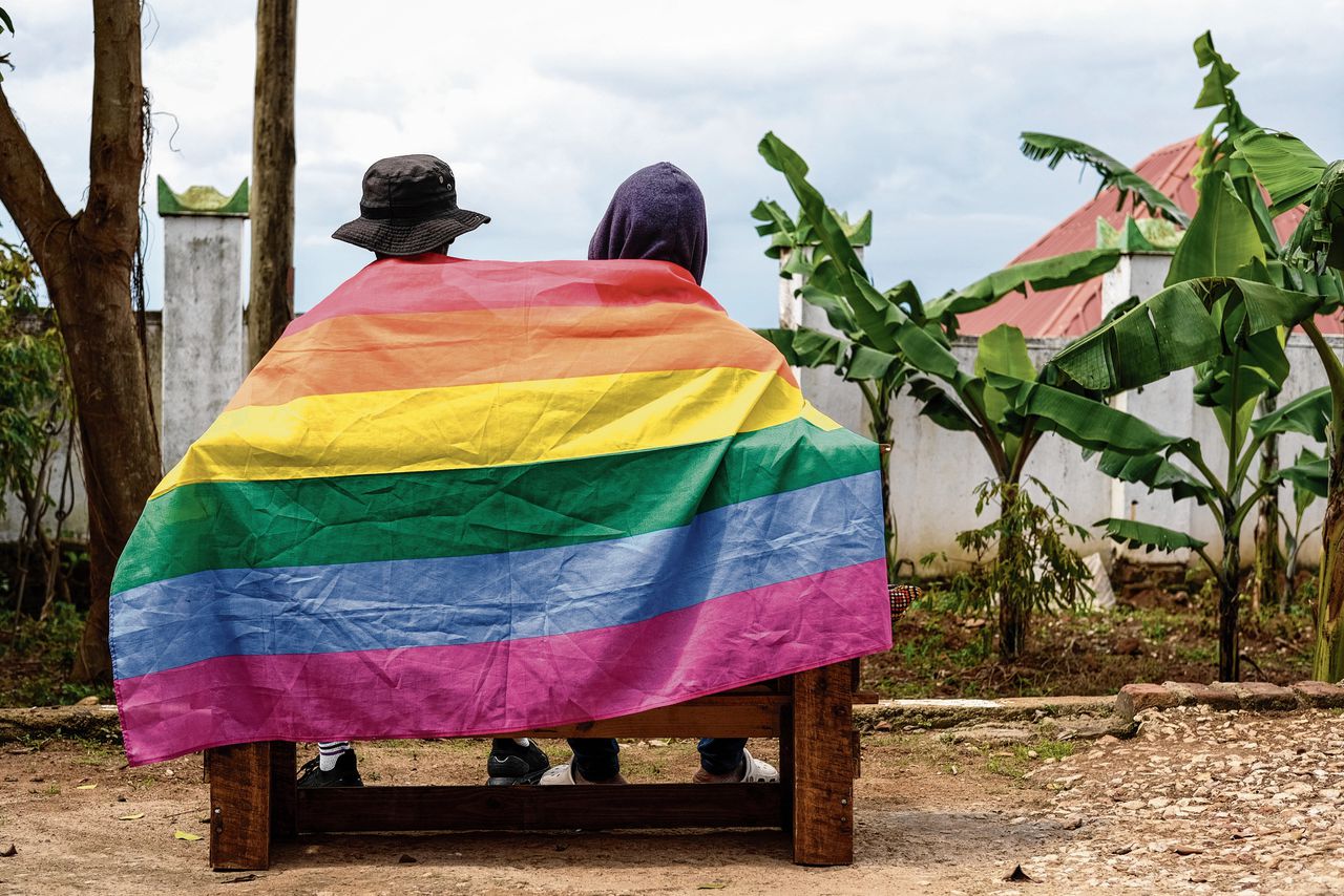 Een Oegandese homokoppel poseert met de lhbti-vlag, 25 maart j.l..