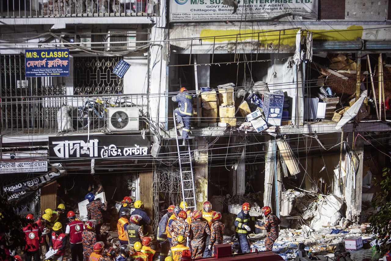 Brandweermensen inspecteren de ravage bij het gebouw in Dhaka waar de explosie plaatsvond.