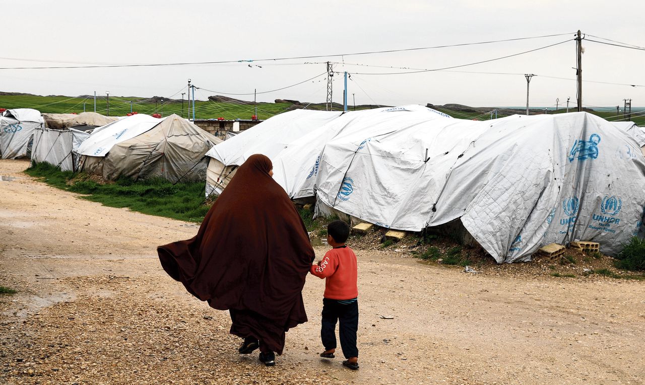 Een vrouw loopt met haar kind door vluchtelingenkamp al-Roj in het Noorden van Syrië.