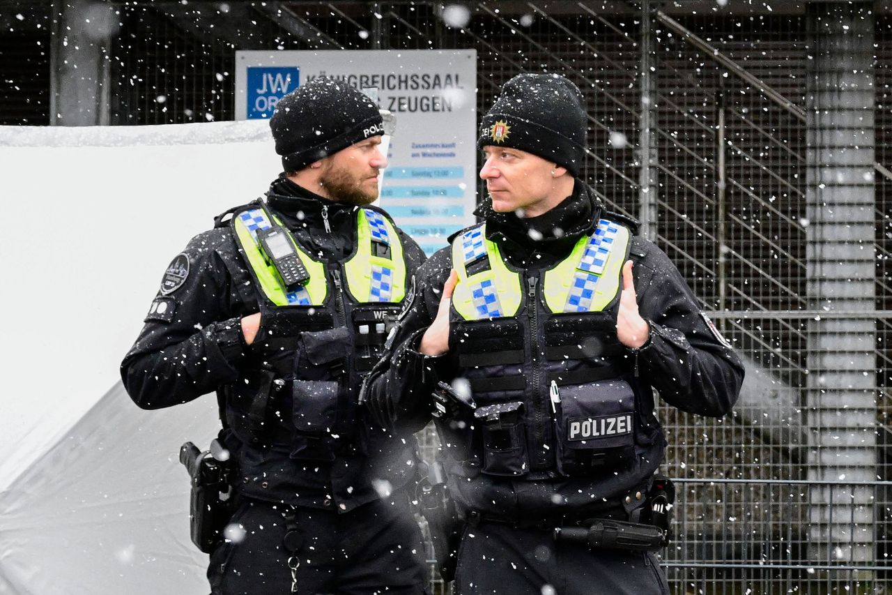 Twee agenten staan op wacht bij de „koninkrijkszaal” van de Jehova’s getuigen in Hamburg, waar een schutter donderdagavond zichzelf en zeven anderen van het leven beroofde.