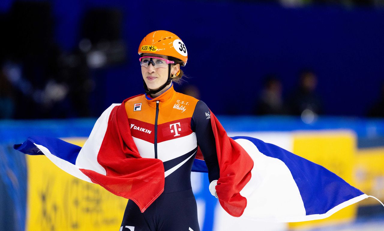 Suzanne Schulting met de Nederlandse vlag na haar triomf op de 1.500 meter.